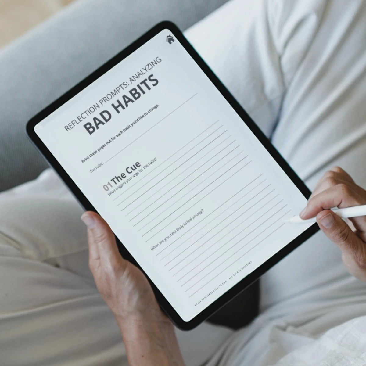 Digital habit tracker workbook page shown on a tablet held in hands.