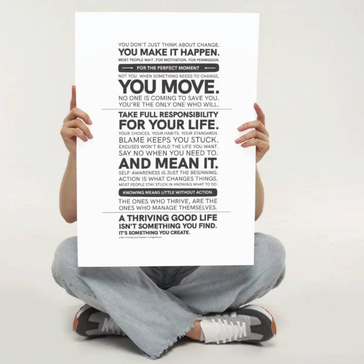 Person sitting cross legged holding the Thriving Good Life Manifesto Poster — bold black-and-white motivational wall art about self-management and accountability.